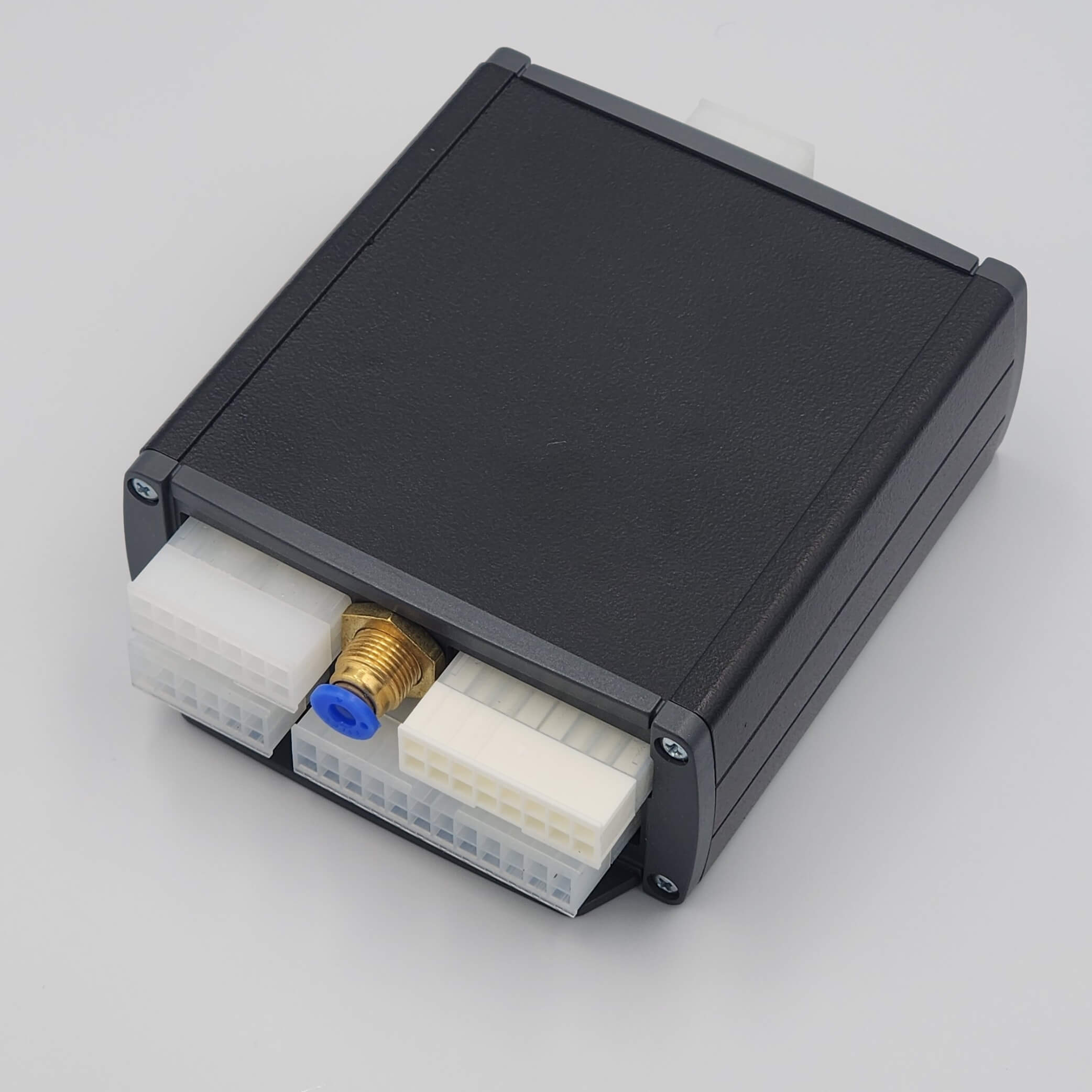 Compact black device with white connectors and brass fitting.