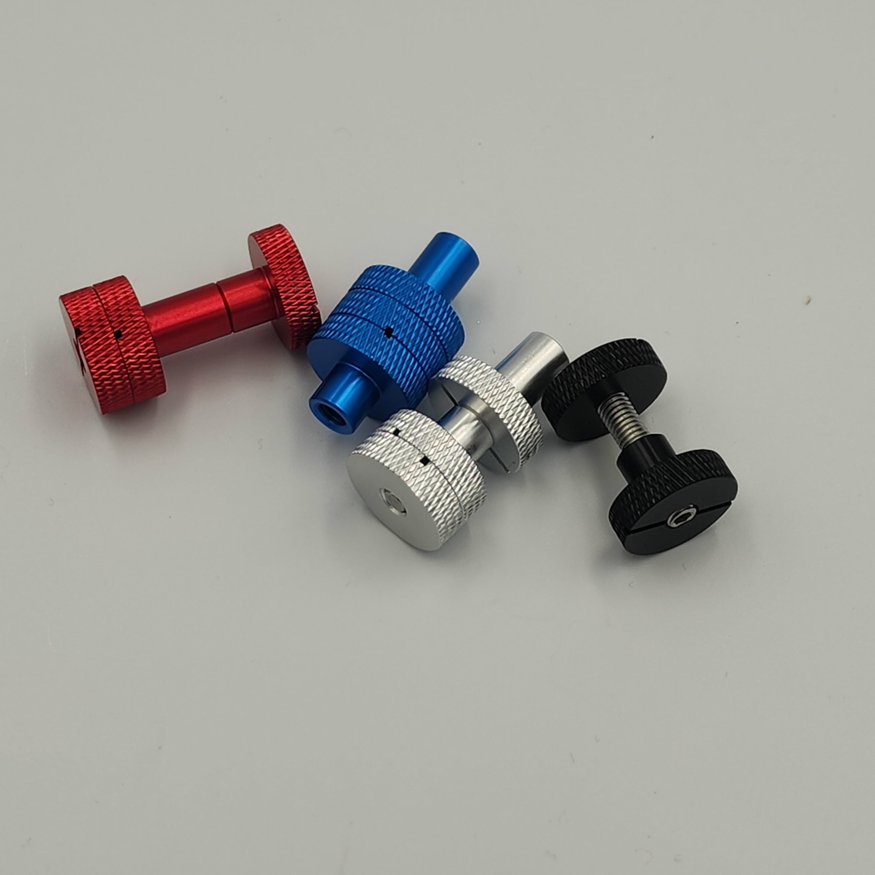 20240528_122059 Red, blue, silver, and black thumb screws.